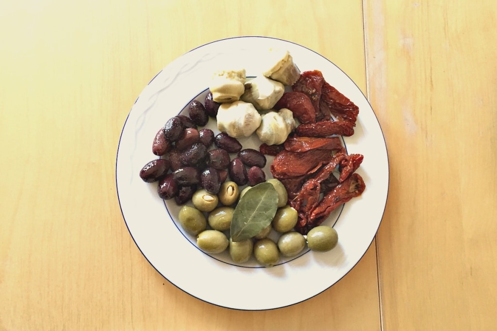 Raclette Antipasti mit grünen und schwarzen Oliven, Artischocken und getrockneten Tomaten Raclette Antipasti mit grünen und schwarzen Oliven, Artischocken und getrockneten Tomaten